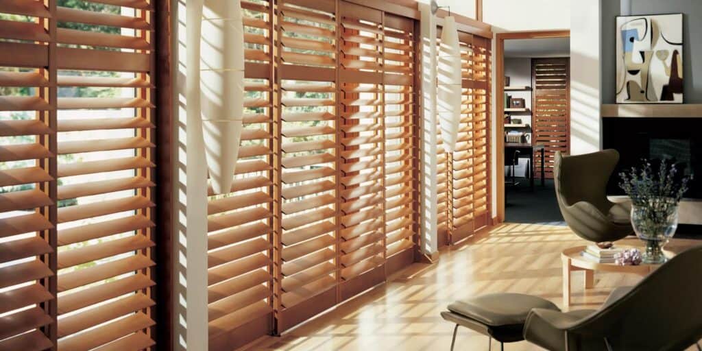 Close-up of wooden window shutters with sunlight casting shadows, modern interior design with natural wood accents, cozy living space, functional window treatments, contemporary decor ambiance.
